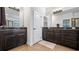 Bathroom with double vanity with dark cabinets, tile flooring, granite counters, and white trim throughout at 569 Bellflower Way, Clermont, FL 34715