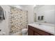 Neutral bathroom with a brown vanity, white toilet and floral patterned shower curtain at 569 Bellflower Way, Clermont, FL 34715