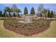 Landscaped Highland Ranch entrance with stone signage, palm trees, and manicured grounds at 569 Bellflower Way, Clermont, FL 34715