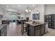 Open floorplan kitchen island with granite counters overlooking dining and living spaces at 569 Bellflower Way, Clermont, FL 34715