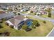 An aerial view shows a home with a screened-in pool in a well-maintained neighborhood at 592 Netherwood Pl, The Villages, FL 32163