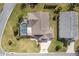 Aerial view shows a beautiful home with a screened-in pool and a well-manicured lawn at 592 Netherwood Pl, The Villages, FL 32163