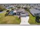 An aerial view of a home with a screened-in pool, a well-maintained lawn, and a custom painted driveway at 592 Netherwood Pl, The Villages, FL 32163