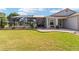 Backyard of a single-story home with a lush green lawn and enclosed screened in patio at 592 Netherwood Pl, The Villages, FL 32163