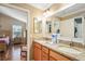 Bathroom featuring a double vanity with granite countertop with view to bedroom and walk-in closet at 592 Netherwood Pl, The Villages, FL 32163