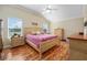 Primary bedroom with vaulted ceiling, wood floors, ceiling fan and light colored wood bedroom set at 592 Netherwood Pl, The Villages, FL 32163