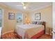 Bedroom with hardwood floors, light beige walls, a ceiling fan, and a large window at 592 Netherwood Pl, The Villages, FL 32163