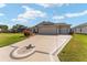 Wide driveway leading to a charming single-story home with a large garage and screened in patio at 592 Netherwood Pl, The Villages, FL 32163