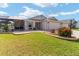 Charming single-story home with a lush green lawn and landscaped garden beds at 592 Netherwood Pl, The Villages, FL 32163