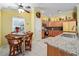 Cozy kitchen and dining area with tile floors, wooden cabinets, and granite countertops at 592 Netherwood Pl, The Villages, FL 32163