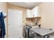 Laundry room with a washer, dryer, white cabinets and tan walls at 592 Netherwood Pl, The Villages, FL 32163