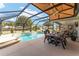 The patio is perfect for outdoor dining, featuring a pool, fan and screened enclosure at 592 Netherwood Pl, The Villages, FL 32163