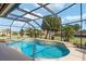 Inviting screened-in pool with tile border, waterfall feature, and sunny views of the lush surrounding landscaping at 592 Netherwood Pl, The Villages, FL 32163