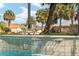 Close-up of pool waterfall detail featuring a fun alligator statue decoration and refreshing water at 592 Netherwood Pl, The Villages, FL 32163