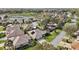 An aerial view of homes in a community, showcasing lush lawns and mature trees at 610 Espana St, Lady Lake, FL 32159