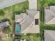 Aerial view showcasing a home with a pool, screened lanai, lush landscaping, and a well-manicured lawn at 610 Espana St, Lady Lake, FL 32159