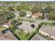 Overhead view of a residential neighborhood, featuring a home with a screened pool and lush landscaping at 610 Espana St, The Villages, FL 32159