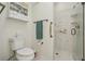 Bathroom featuring a toilet and updated walk-in shower with marble walls at 610 Espana St, The Villages, FL 32159