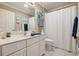 Bathroom showcasing white cabinets, a large mirror, and a shower with curtain at 610 Espana St, The Villages, FL 32159