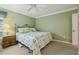 Cozy bedroom with soft carpet, a floral comforter, and side table with lamp at 610 Espana St, The Villages, FL 32159