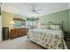 Comfortable bedroom with a floral-patterned quilt, and an ornate metal headboard, and a dresser with mirror at 610 Espana St, The Villages, FL 32159