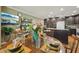 Cozy dining area featuring a wooden table, a TV, and a view into the modern kitchen at 610 Espana St, The Villages, FL 32159