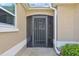 Close up on the front door which features a decorative screen and neutral paint with a beige trim at 610 Espana St, Lady Lake, FL 32159