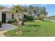 Beautifully landscaped front yard with a welcome sign and mature palm tree at 610 Espana St, The Villages, FL 32159