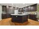 Kitchen boasting a large island with granite counters, dark wood cabinets and stainless steel appliances at 610 Espana St, The Villages, FL 32159