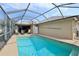 A clear blue pool with screened enclosure with outdoor furniture for relaxation and enjoyment at 610 Espana St, Lady Lake, FL 32159