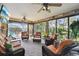 Bright sunroom featuring wicker furniture, ceiling fans, and views of the pool and landscaped yard at 610 Espana St, Lady Lake, FL 32159