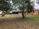 View of the home's backyard featuring a lawn, some trees and a screened in back porch at 616 N Hartley Cir, Deltona, FL 32725