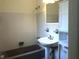 Bathroom featuring a white tile wall, gray bath tub and white sink at 616 N Hartley Cir, Deltona, FL 32725