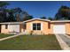 Charming single-story home with an orange exterior, white trim, a well-manicured lawn, and an attached garage at 616 N Hartley Cir, Deltona, FL 32725