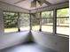 Screened-in porch with painted floor, ceiling fan, and windows looking out to the yard at 616 N Hartley Cir, Deltona, FL 32725