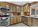 Well-lit kitchen features stainless steel appliances, tiled backsplash, and wood cabinets at 630 E 8Th Ave, Mount Dora, FL 32757