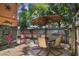 Cozy outdoor patio area with seating, a table, a decorative umbrella, and lush landscaping creating a relaxing space at 630 E 8Th Ave, Mount Dora, FL 32757