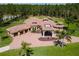 Stunning aerial view of an estate home featuring a terracotta roof, circular driveway and lush landscaping at 6801 Silver Charm Ct, Leesburg, FL 34748