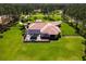 Gorgeous aerial view of the property, showcasing the pool, surrounding greenery, and impressive roof design at 6801 Silver Charm Ct, Leesburg, FL 34748