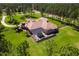 Aerial view of the house with surrounding trees and a pool covered with screen at 6801 Silver Charm Ct, Leesburg, FL 34748