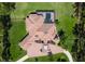 Aerial view of the home highlighting the tile roof, screened-in pool, and lush landscaping at 6801 Silver Charm Ct, Leesburg, FL 34748