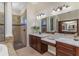 Bathroom with dual sinks, marble countertops, and a glass shower at 6801 Silver Charm Ct, Leesburg, FL 34748