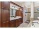 Bathroom with granite countertops, dual sinks, and a separate glass shower at 6801 Silver Charm Ct, Leesburg, FL 34748