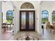 Grand foyer featuring tile flooring, arched doorways, and double front doors with custom glass work at 6801 Silver Charm Ct, Leesburg, FL 34748