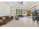 Comfortable living room space featuring tile floors, ceiling fan, and sliding doors with views of the outdoor living space at 6801 Silver Charm Ct, Leesburg, FL 34748