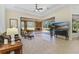 Bright living room featuring a ceiling fan, tile floors, and sliding glass doors to the outside patio at 6801 Silver Charm Ct, Leesburg, FL 34748