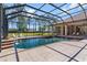 Inviting screened-in pool with spa and tranquil waterfall feature and ample patio space, perfect for outdoor entertaining at 6801 Silver Charm Ct, Leesburg, FL 34748