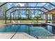 Inviting pool and spa area within a screened enclosure, surrounded by lush landscaping at 6801 Silver Charm Ct, Leesburg, FL 34748