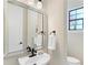 A stylish powder room featuring a modern mirror and fixtures, providing a convenient and elegant space for guests at 6801 Silver Charm Ct, Leesburg, FL 34748