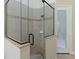 A detailed view of the glass enclosed shower with a rain shower head and tiled walls at 6801 Silver Charm Ct, Leesburg, FL 34748